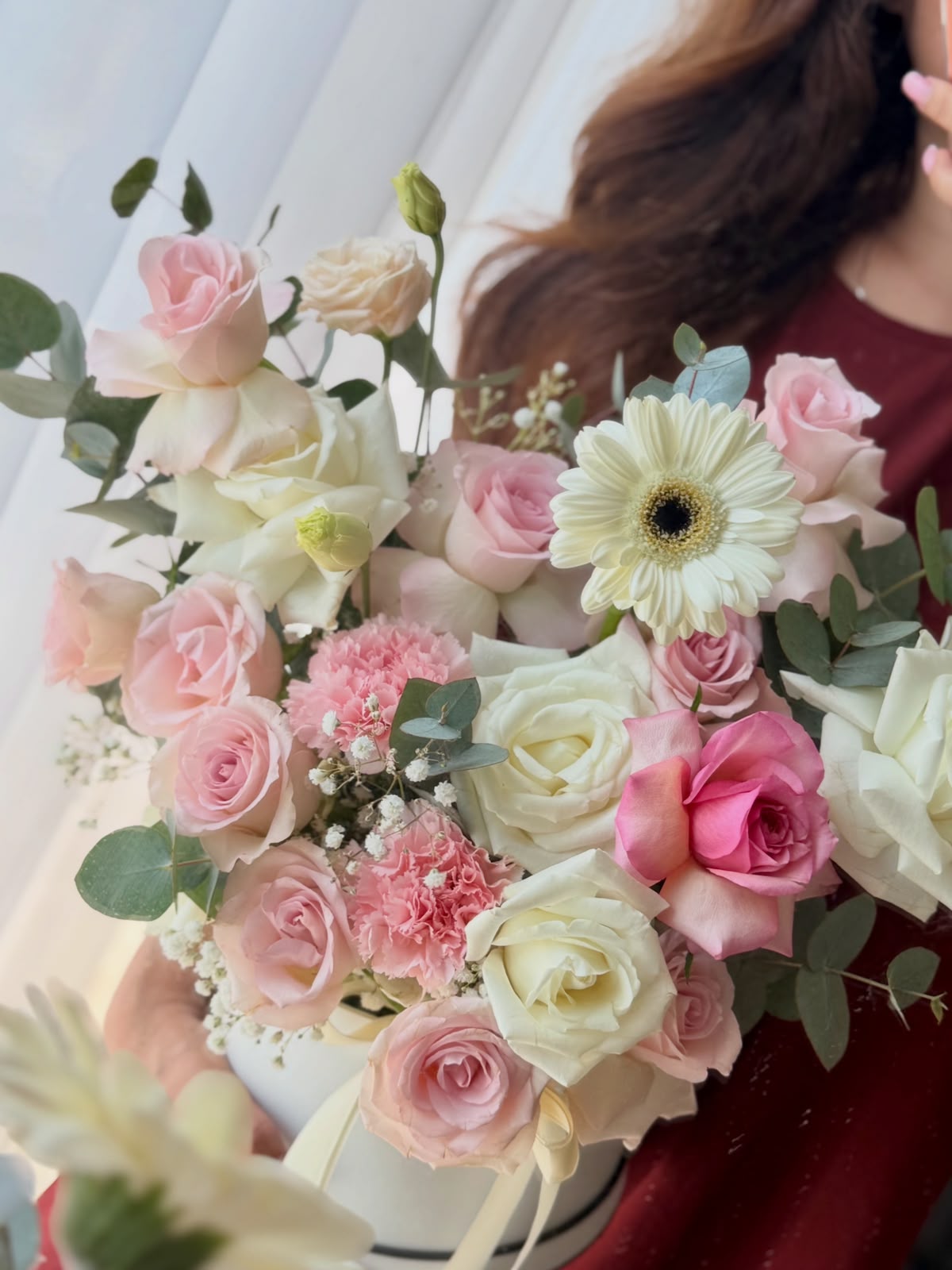 Close-up of MÉGA's blush and ivory roses, pink carnations, pale gerbera and eucalyptus